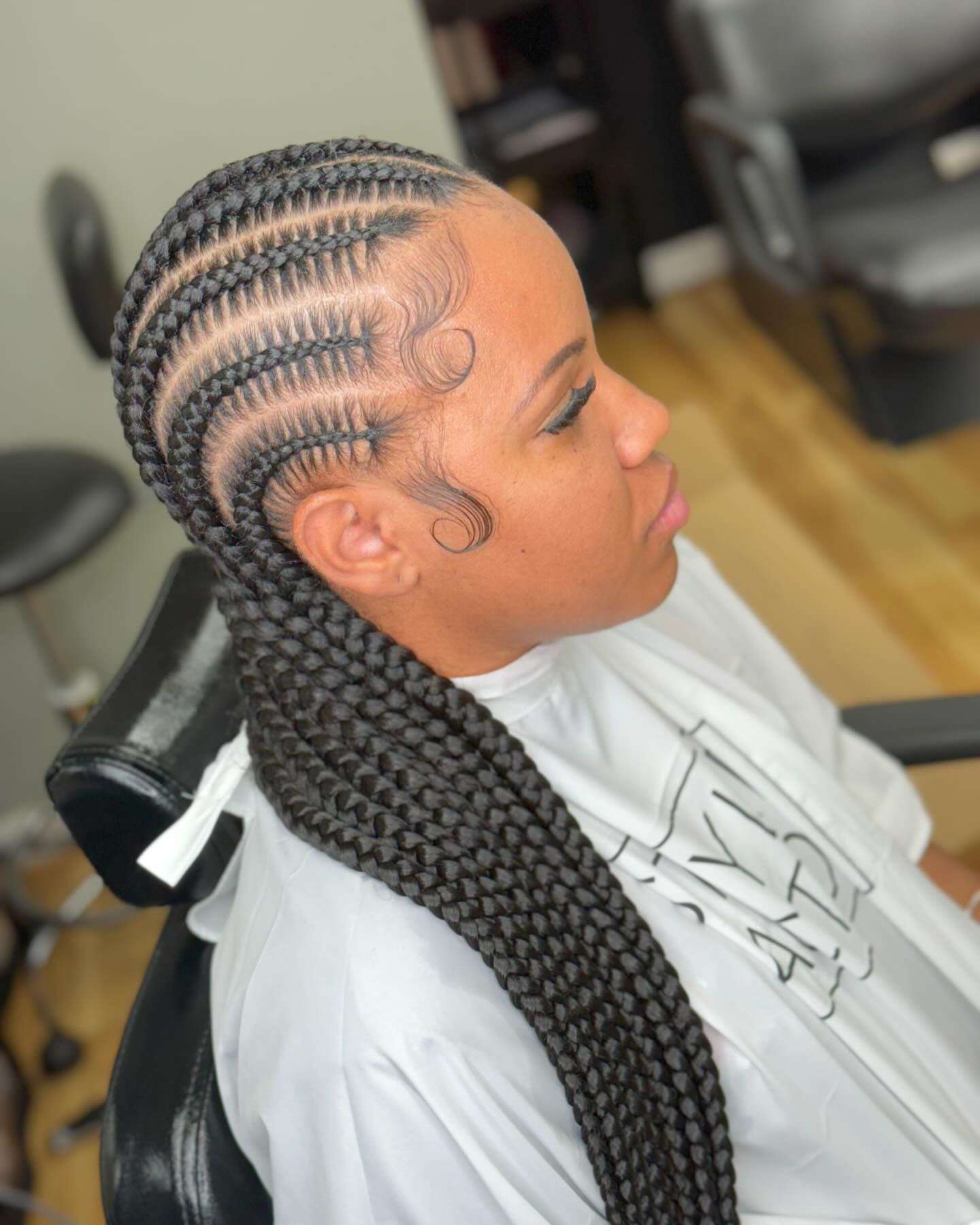 woman in a styling chair with straight back stitch braids