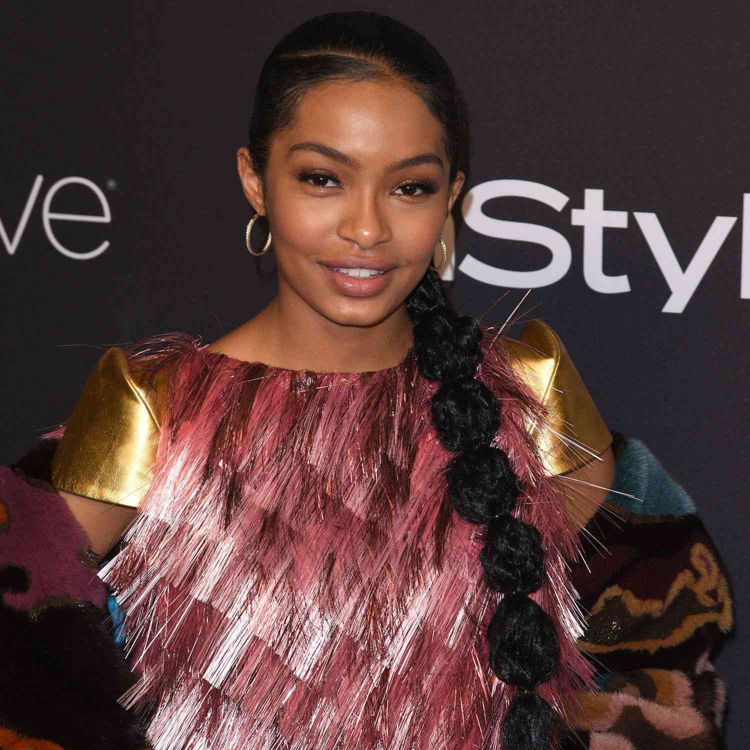 Yara Shahidi with a deep side part and a bubble ponytail