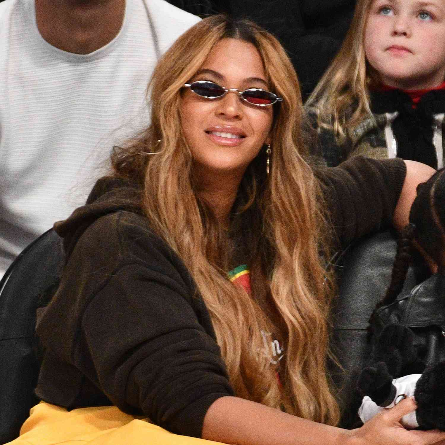 Beyonce wears an ultra-long, wavy hairstyle with face-framing layers and tiny sunglasses