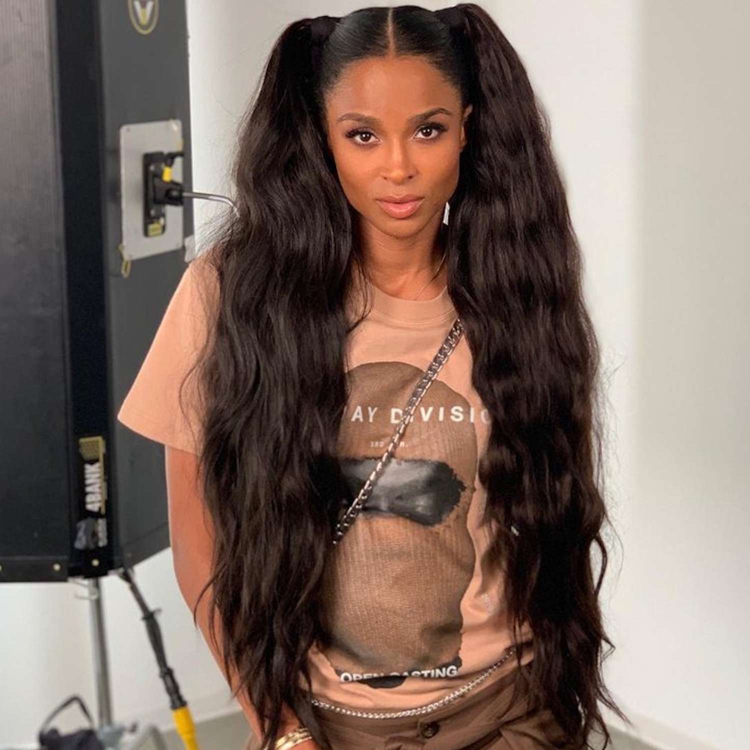 Ciara wears a voluminous, wavy high pigtails hairstyle and a graphic tee