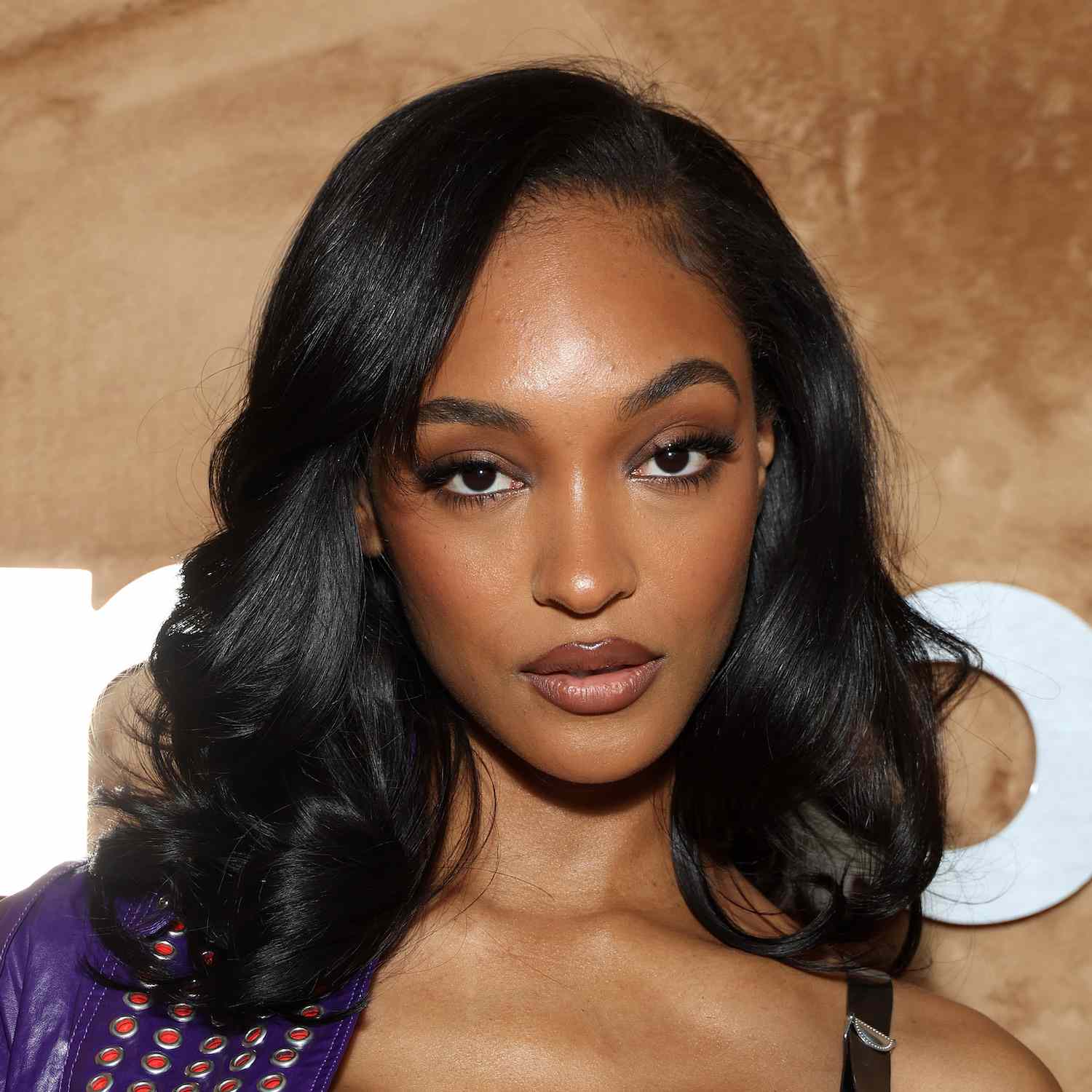 Jourdan Dunn wears a long bob hairstyle with bouncy curls and face-framing layers