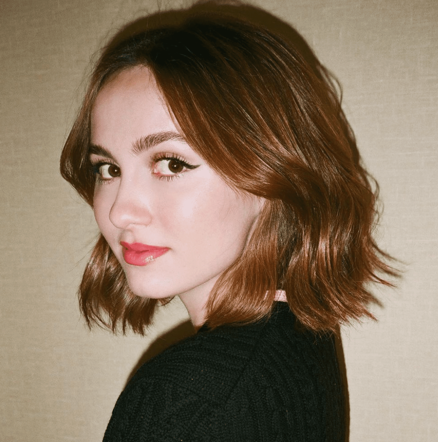 Maude Apatow looks over her shoulder with a tousled copper colored bob