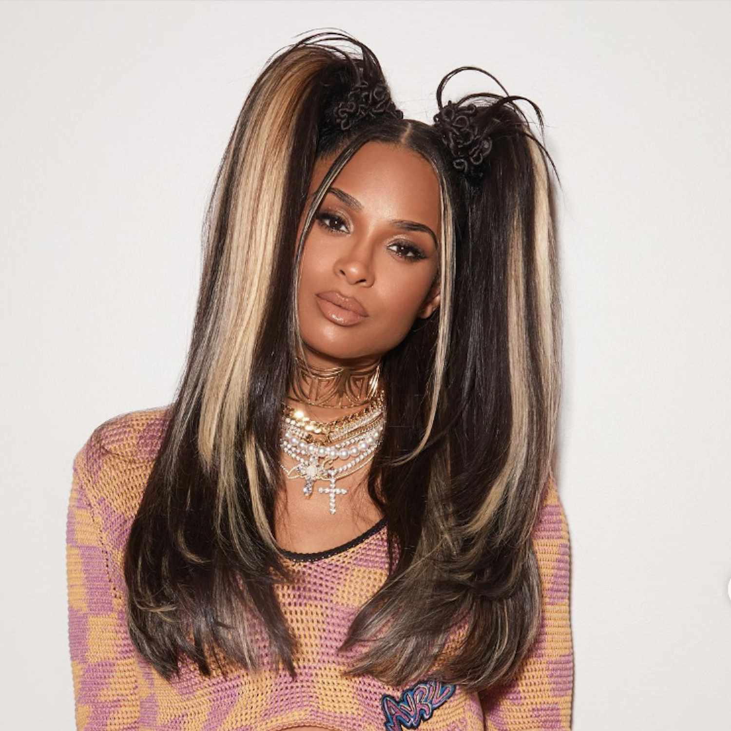 Ciara wears high pigtails with blonde streaks and stylized bases