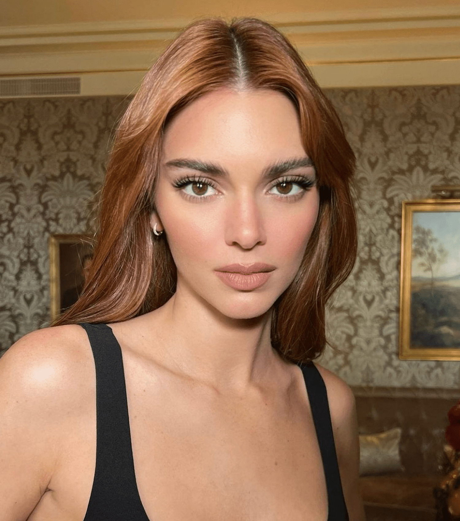 Kendall Jenner wears minimal muted makeup and a center part on her copper colored hair