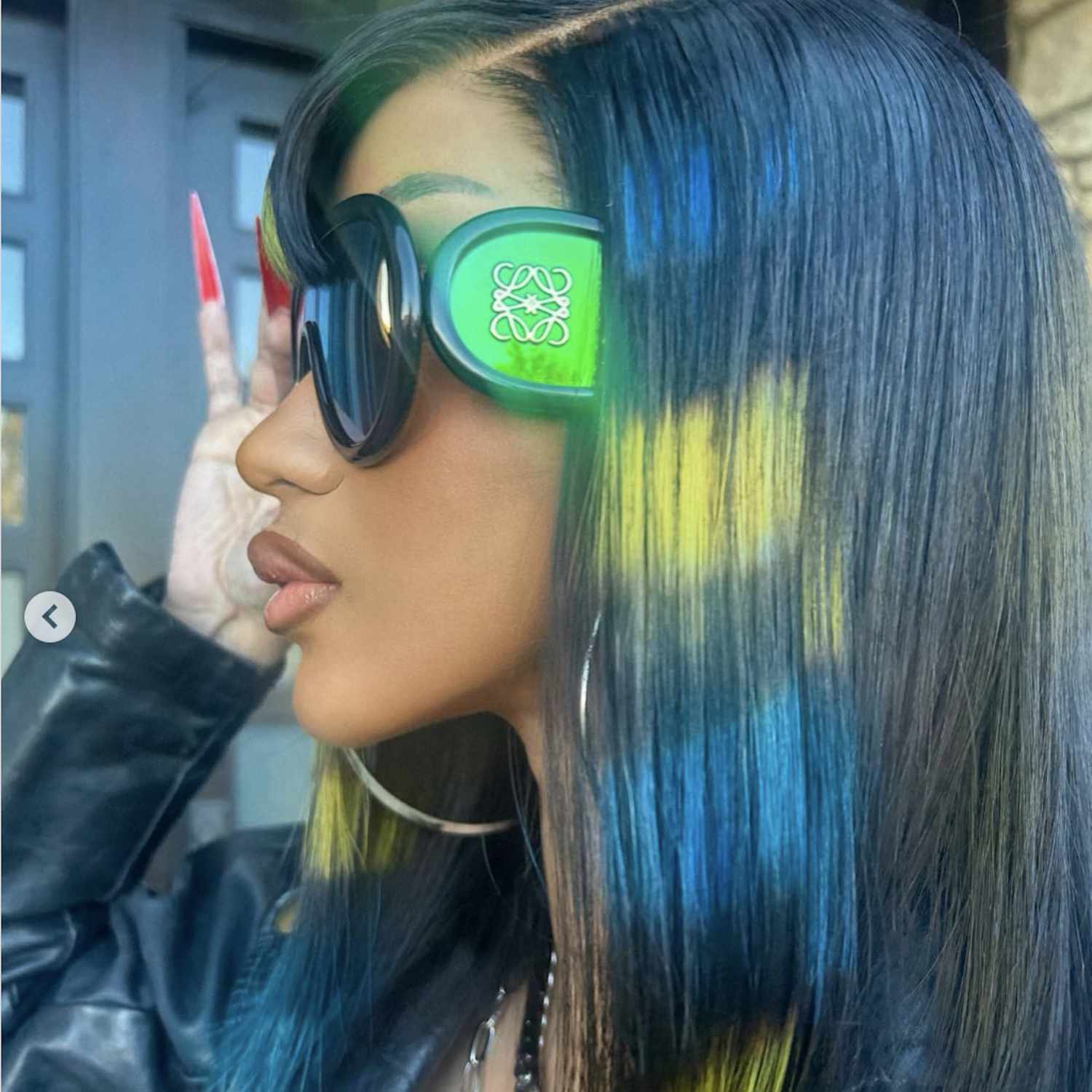Cardi B with sleek black hair with green accents