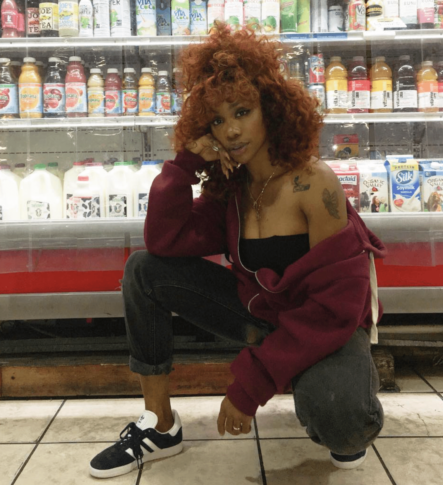 SZA SQUATS DOWN IN A BODEGA MARKET TO POSE FOR A PHOTO