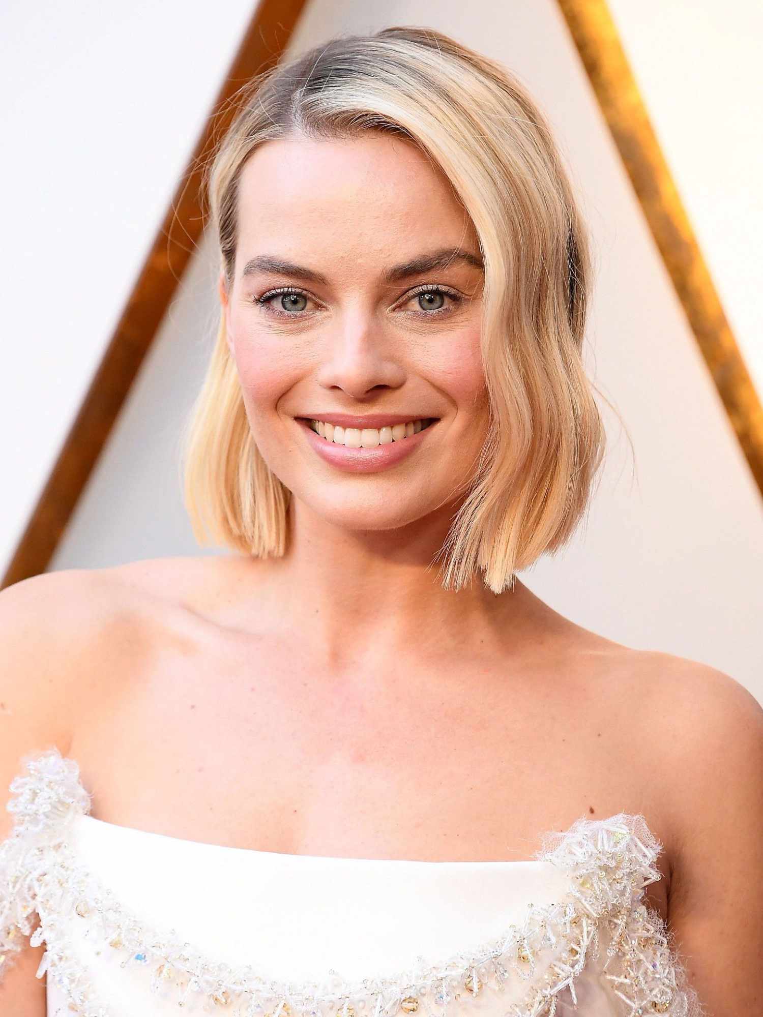 Margot Robbie with a blonde bob haircut styled in an S-wave