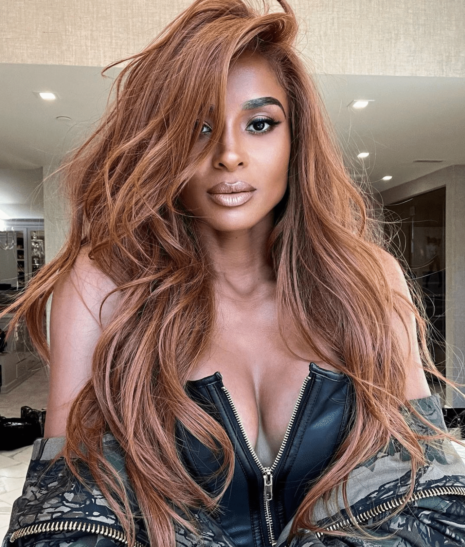 CIARA WEARS A COPPER HAIR COLOR ON LONG TOUSLED STRANDS WITH A VOLUMINOUS SIDE PART