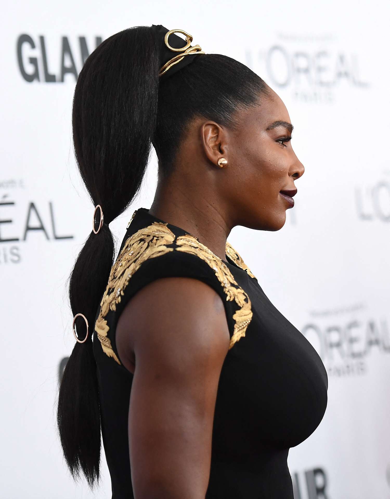 Serena Williams with a high bubble ponytail with gold accessories