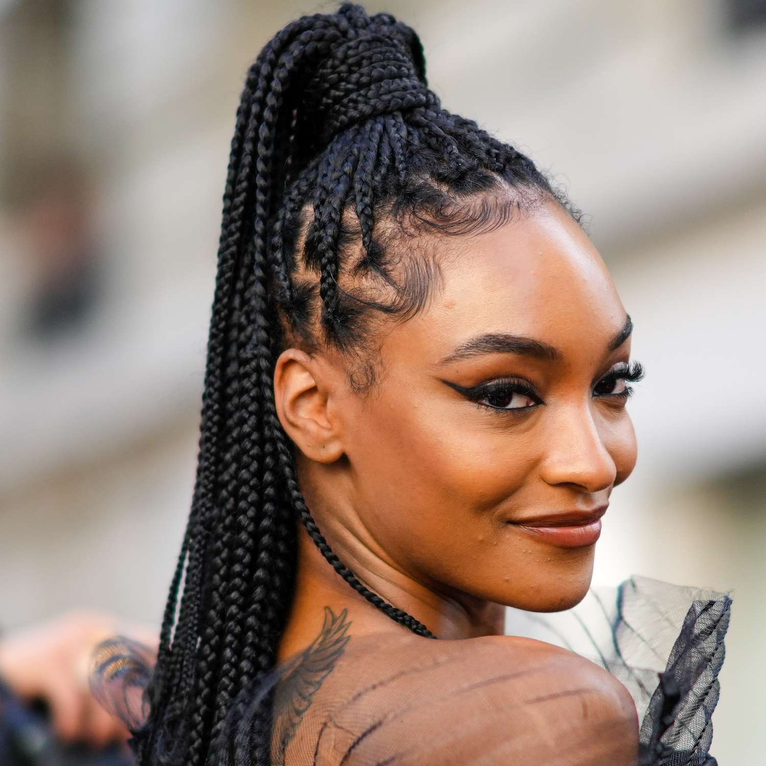 Jourdan Dunn wears box braids pulled up into a high, hair wrapped ponytail