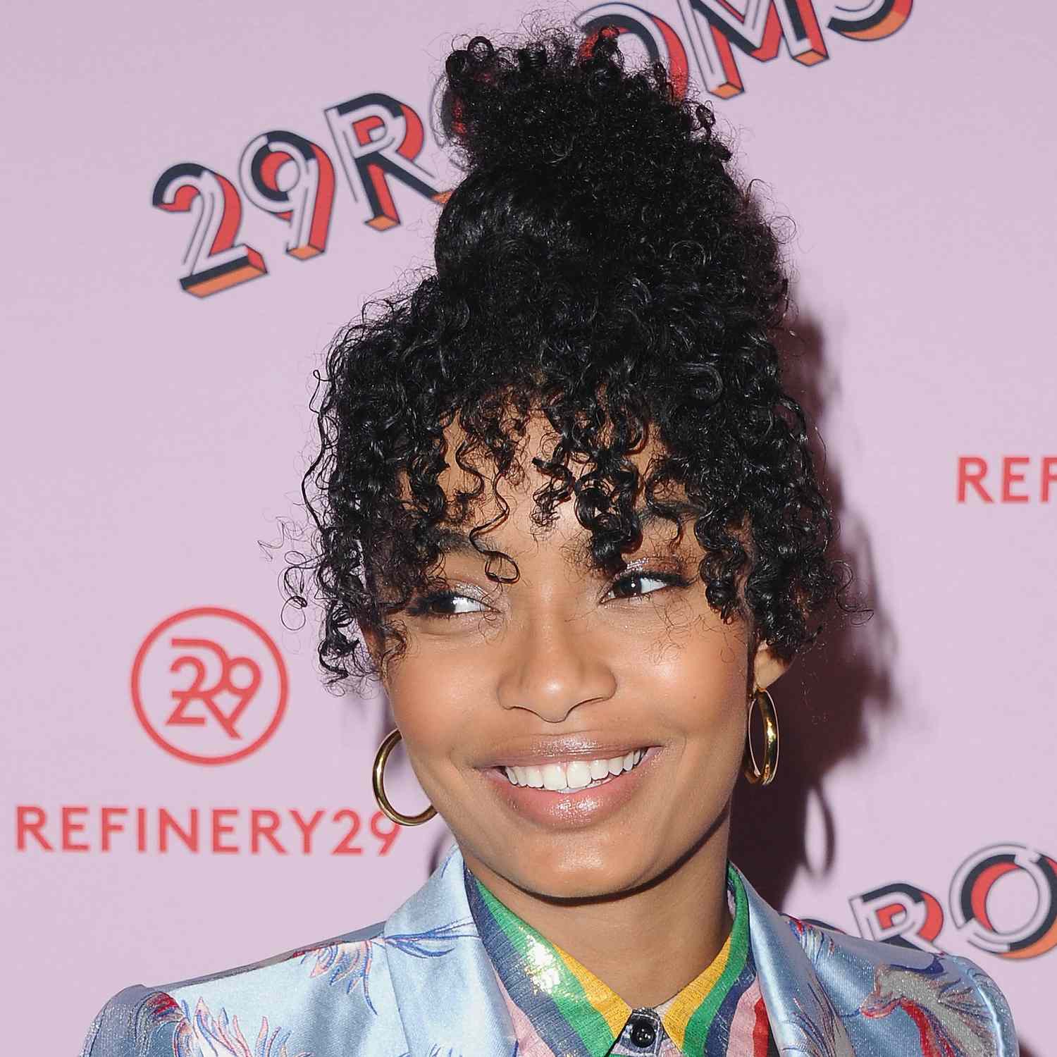 Yara Shahidi wears naturally curly french bangs and an updo to an LA event