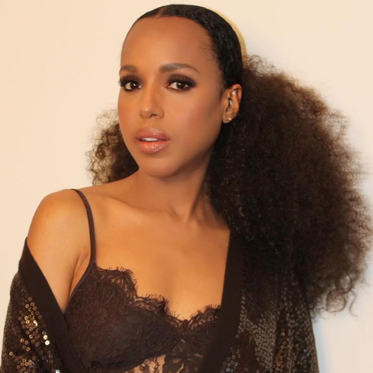 Kerry Washington wears her natural hair texture and espresso brunette hair color in a low voluminous ponytail