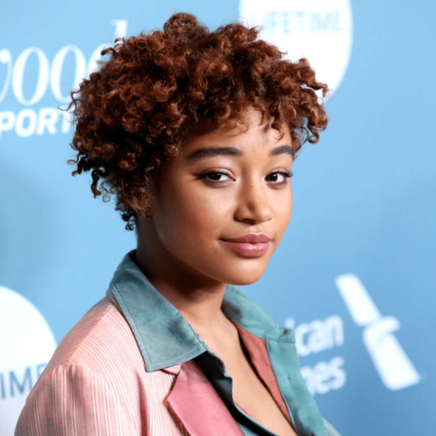 Amandla Stenberg with a cropped, curly copper-cola colored haircut