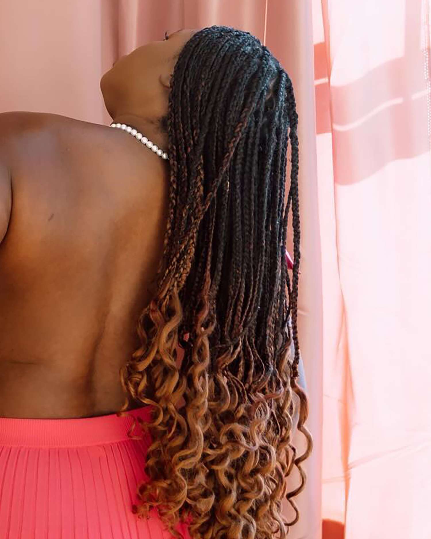 rear view of a woman's head with long ombre french curl braids