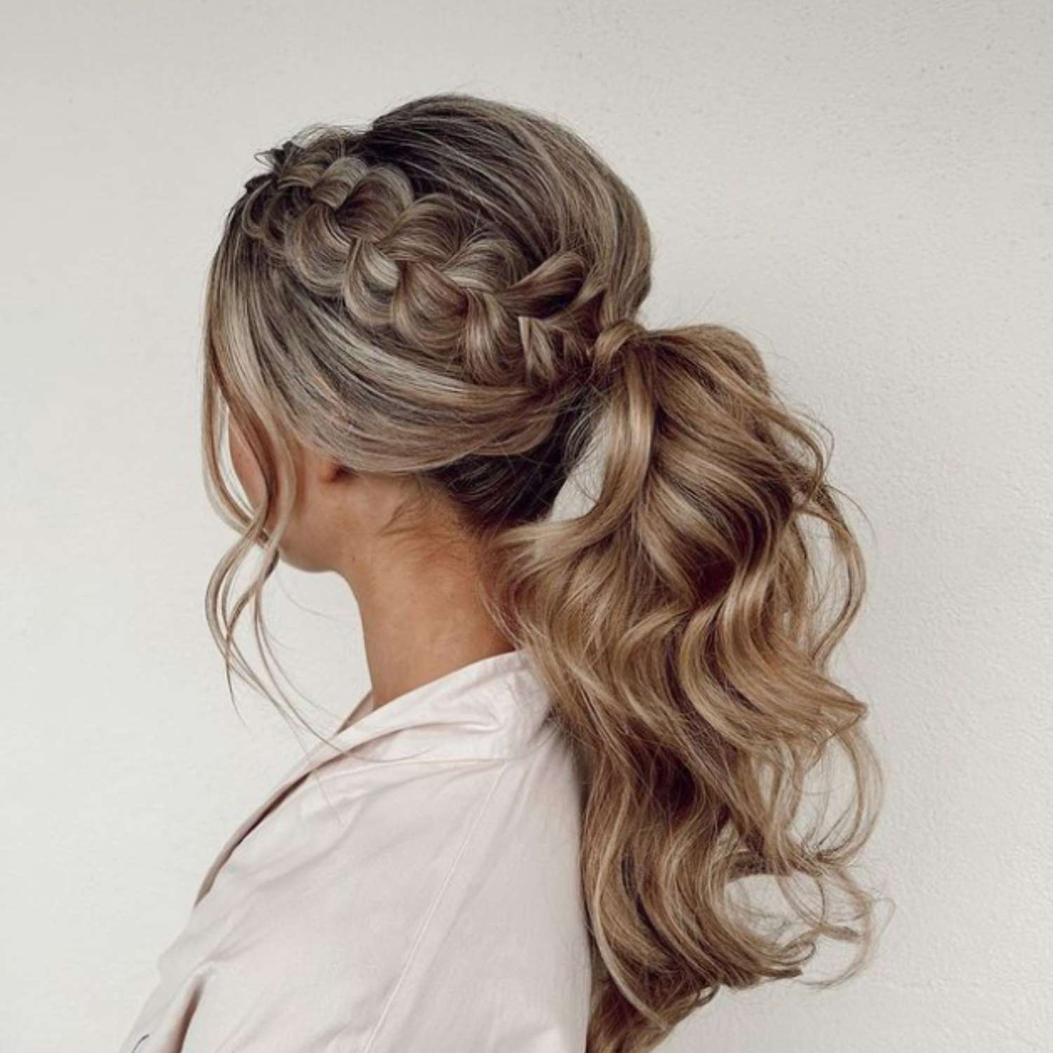 Voluminous ponytail with a side braid.