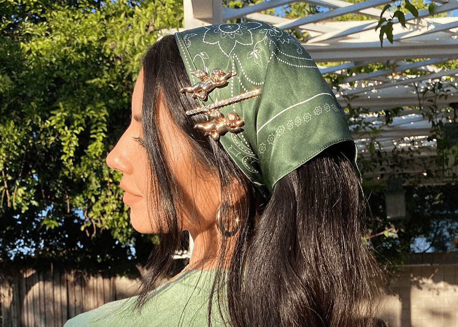 Justine Marjan with three gold barrette and silk green scarf in her hair